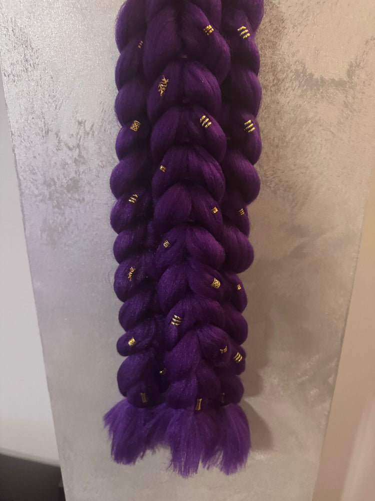 Purple braided hair extensions with gold accents on a textured white background