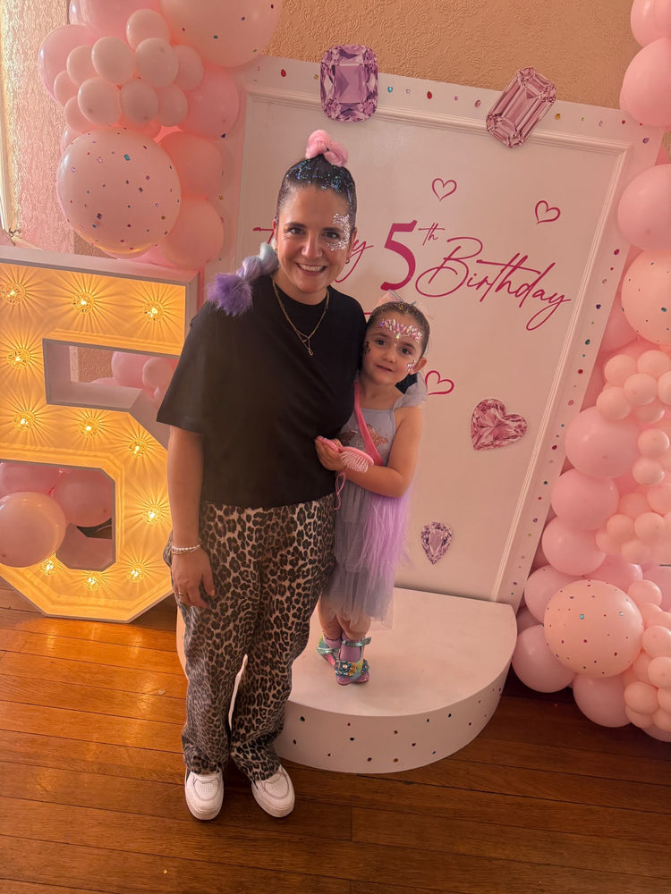 A guest and a girl with glitter roots and face gems at Rose's 5th birthday party