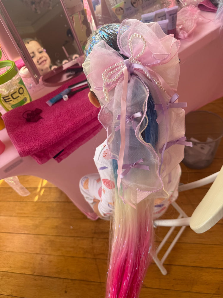 Pink ombre ponytail with a pearl organza bow at a glitter braid party