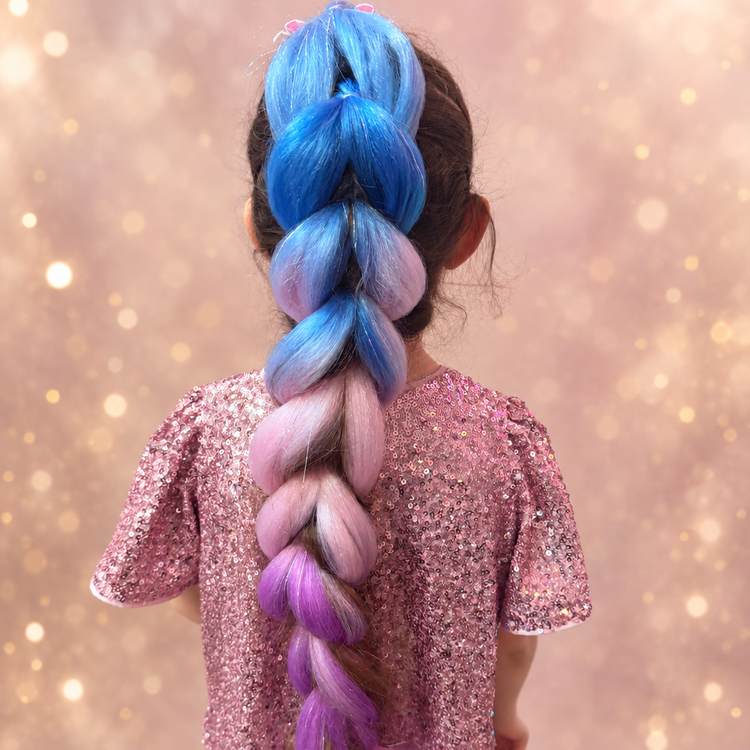 Back view of a girl in a sequinned pink top wearing a blue, pink and purple Jumbo Dragon Hair Braid against a blush and gold glitter backdrop